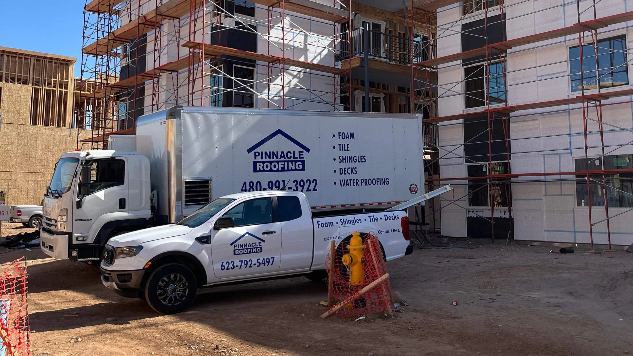 Pinnacle Roofing trucks at a commercial construction site in the Phoenix metro