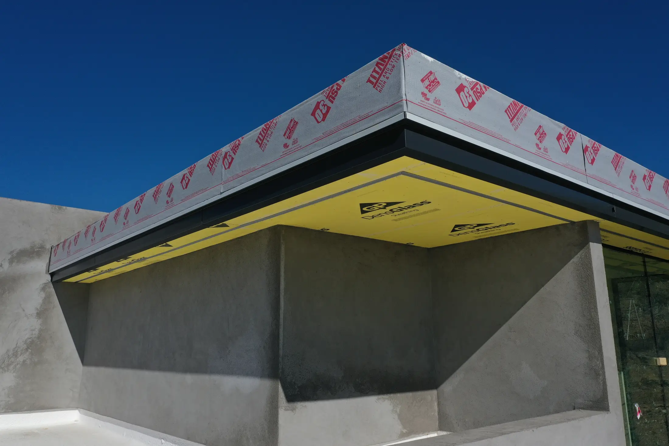 Roof parapet corner prepped with underlayment on a job site
