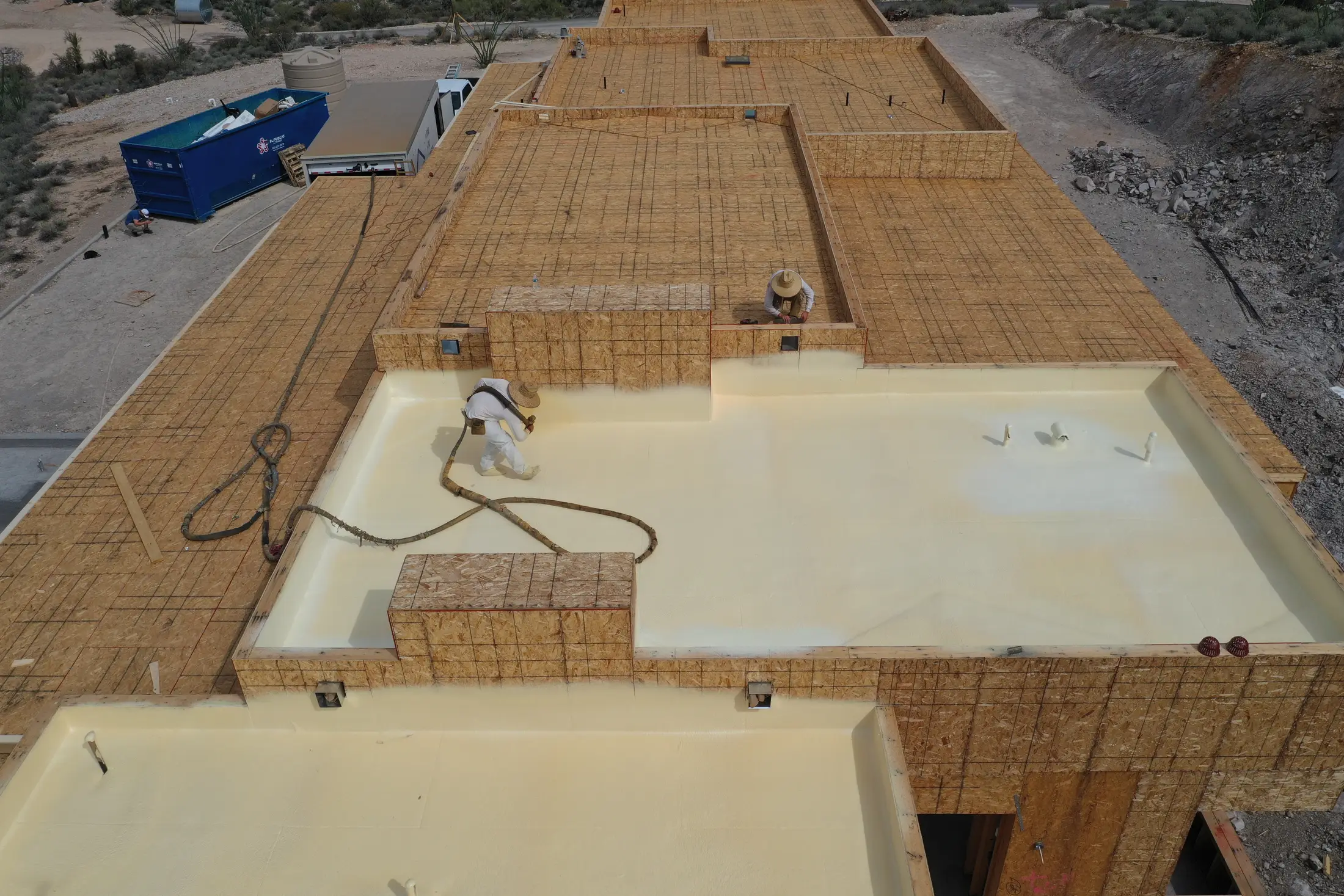 Foam roofing being sprayed on a low-slope roof